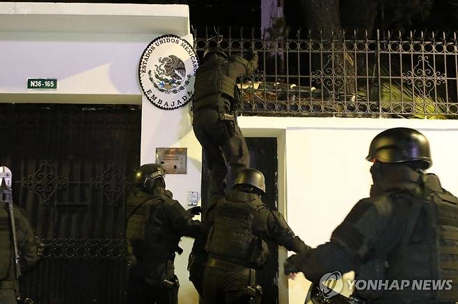 지난 5일(현지시간) 키토 소재 멕시코 대사관 담벼락을 넘어 진입하는 에콰도르 경찰 [AFP 연합뉴스 자료사진. 재판매 및 DB 금지]
