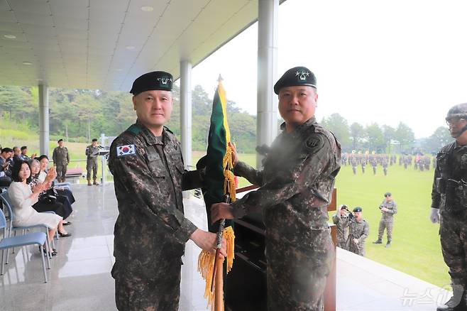 육군 제7기동군단장 이·취임식에서 손식 지상작전사령관(왼쪽)이 박재열 신임 7기동군단장에게 부대기를 이양하고 있다.(7군단 제공)