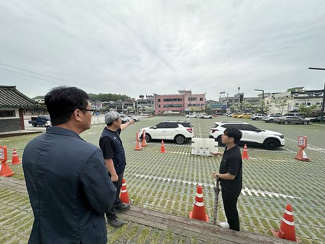 문화재청과 부여군 관계자들이 관북리 유적지 발굴·복원 계획을 설명하고 있다. 앞에 보이는 붉은색 건물들은 매입해 철거할 예정이다. 송인걸 기자