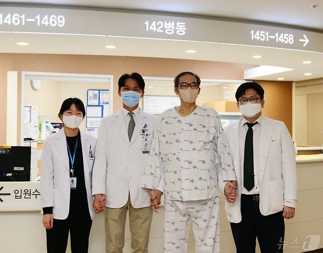 민은기(왼쪽부터)·한기창·이재근 교수가 정민수씨(오른쪽 두번째)와 사진 촬영을 하고 있다.(세브란스병원 제공)