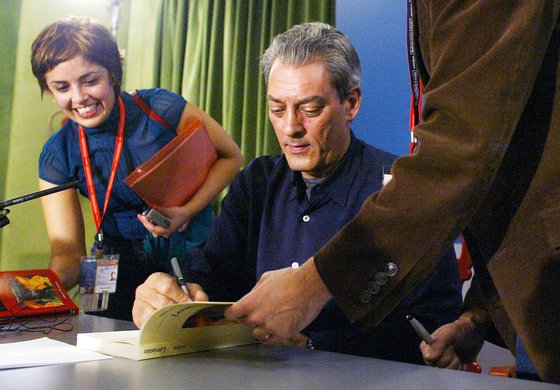 폴 오스터가 2006년 스페인 ‘아스투리아스 왕자상’ 수상에 앞서 사인하고 있다. [AFP=연합뉴스]