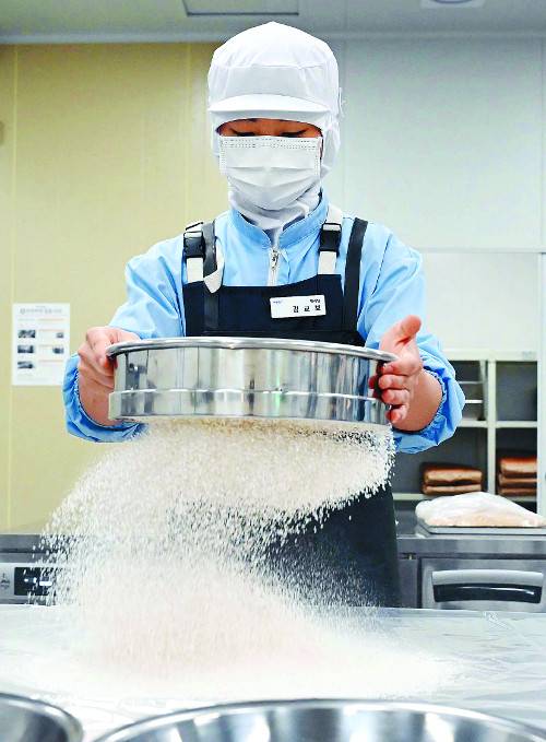 경기도 용인시에 위치한 ‘희망별숲’ 성형실에서 제과팀 사원 김교보씨가 밀가루를 체에 치고 있다. 희망별숲은 삼성전자가 100% 출자한 자회사형 장애인 표준사업장이다. 김씨는 발달장애인 200여명과 함께 쿠키 등 제과류를 생산한다. 이한형 기자