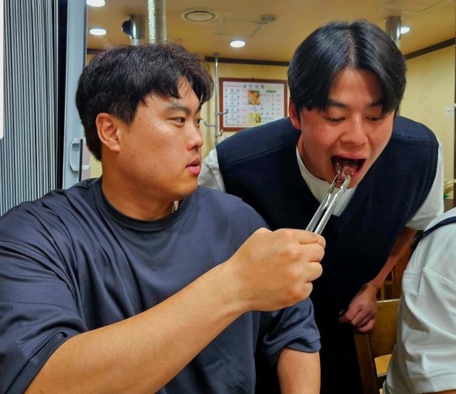 류현진이 노시환에게 고기를 먹여주고 있다. 사진=99코퍼레이션 SNS 캡쳐