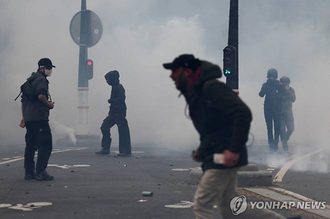 파리 시위 (파리 로이터=연합뉴스) 1일(현지시간) 노동절을 맞아 파리에서 벌어진 시위에서 시위대가 경찰이 뿌린 최루가스 사이로 걸어가고 있다. 2024.5.1