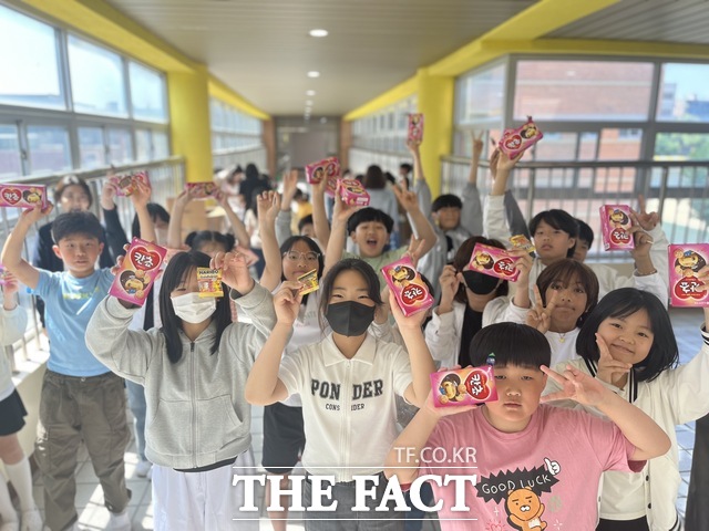 ‘사랑의 등교맞이‘ 행사에 참여한 어린이들이 학부모들이 준비한 선물을 들고 즐거워하고 있다./ 광주양산초등학교