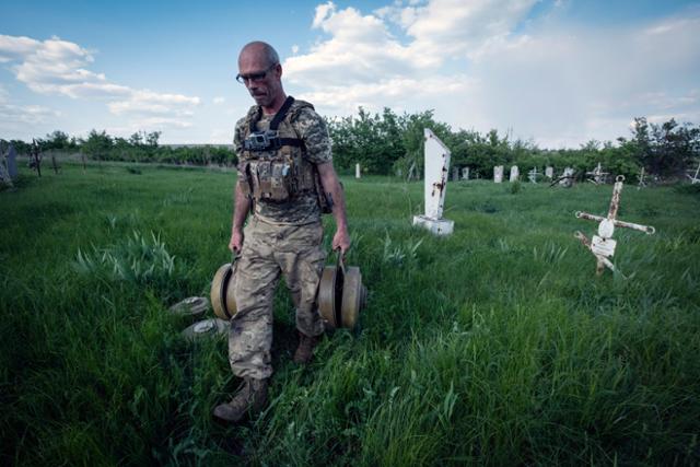 우크라이나 군인이 2일 동부 도네츠크주 크라스노필리야에서 제거한 지뢰를 옮기고 있다. 크라스노필리야=AP 연합뉴스