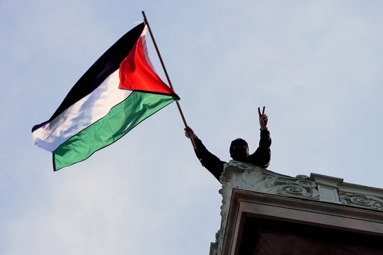 지난 30일 미 컬럼비아대 해밀턴홀에서 한 시위자가 팔레스타인 국기를 흔들고 있다. AP=연합뉴스
