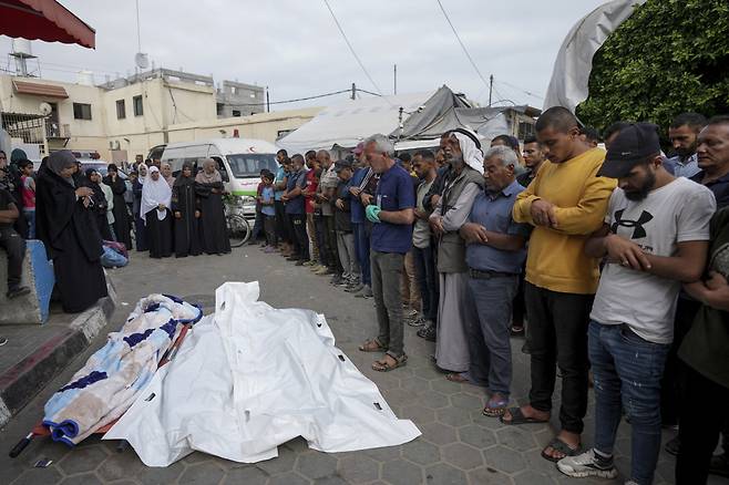 2일(현지시각) 가자지구 데이르 알발라의 알아크사 병원에서 팔레스타인인들이 이스라엘의 공습으로 숨진 희생자들의 시신을 앞에 두고 기도하고 있다./AP=뉴시스