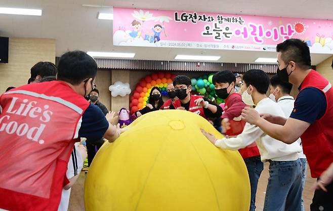 LG전자 임직원들이 지난 2일 서울 강동구 암사재활원에서 열린 ‘오늘은 어린이날’ 행사에서 장애 아동, 청소년들과 함께 작은 운동회에 참여하고 있다. LG전자 제공