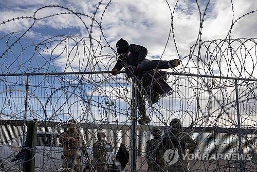미국 국경 울타리 넘는 베네수엘라 이민자  [AFP 연합뉴스 자료사진]