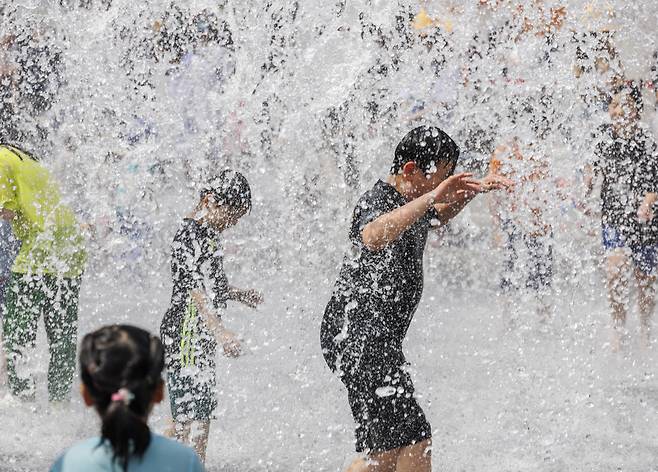 어린이날을 하루 앞둔 4일 오후 서울 종로구 광화문 광장에서 설치된 분수대에서 어린이들이 초여름 더위를 잊기 위해 물놀이를 하고 있다. [연합]