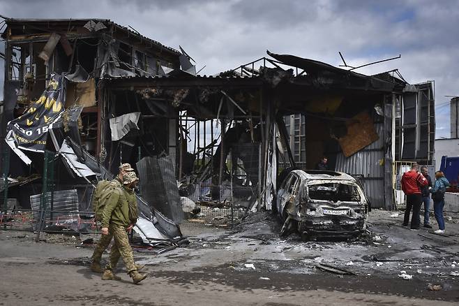 불타버린 드니프로의 한 주택 앞을 지나는 우크라이나군 병사들[AP 연합뉴스]