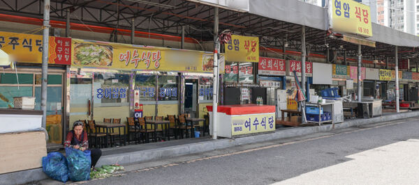 점심식사 시간임에도 불구하고 안산시민시장 식당가가 한산한 모습을 보이는 가운데 한 상인이 점포 앞에서 얼갈이 배추를 다듬고 있다.