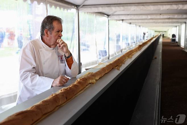 5일(현지시간) 프랑스 파리 근교 쉬렌에서 열린 바게트 쇼에서 세계에서 가장 긴 바게트 만들기에 도전한 제빵사가 오븐에서 나오는 바게트 근처에 서 있다. 2024.05.05/ ⓒ 로이터=뉴스1 ⓒ News1 권진영 기자