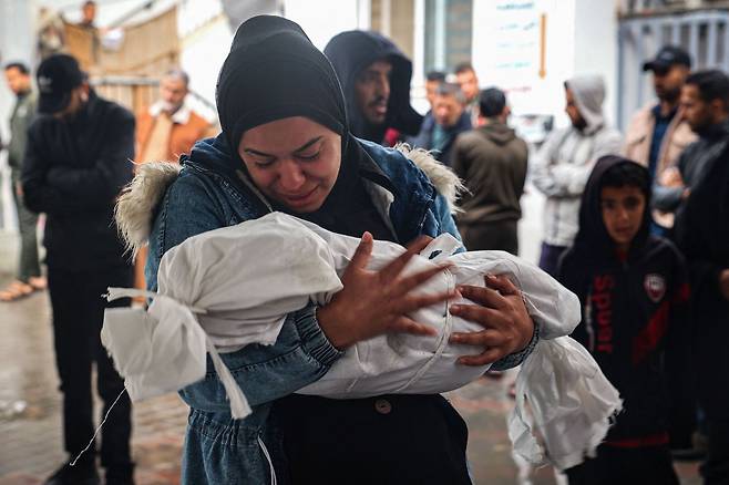 한 팔레스타인 여인이 6일(현지시간) 간밤 가자 남부 라파시에 대한 이스라엘군 공습에 숨진 아이를 부둥켜 안고 통한의 눈물을 흘리고 있다. 2024.05.06 ⓒ AFP=뉴스1 ⓒ News1 권진영기자