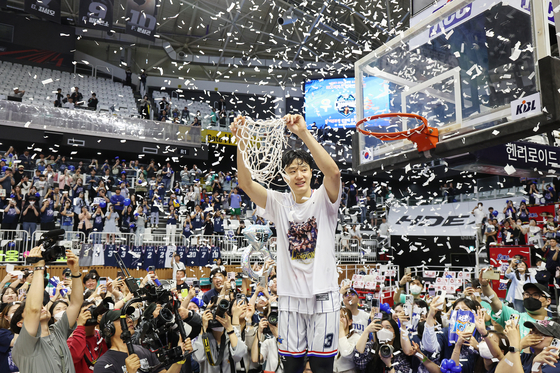 Busan KCC Egis's Heo Ung celebrates winning the 2023-24 KBL Championship after cutting down the net. [YONHAP]