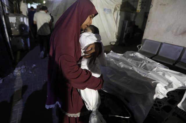 팔레스타인 여성이 5일(현지시간) 가자지구 라파에 있는 알 나자르 병원에서 이스라엘군의 공습으로 사망한 생후 7개월 아기를 들고 있다. AP연합뉴스