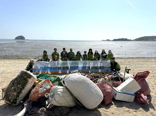 지난 3일 인천 영종도 용유해변에서 허성 대표이사 등 코오롱ENP 임직원들이 환경정화 활동 기념 촬영을 하고 있다. <코오롱ENP>