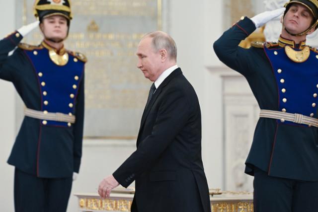 블라디미르 푸틴 러시아 대통령이 지난해 12월 모스크바 크렘린궁에서 경비병들의 경례를 받으며 이동하고 있다. 모스크바=AP 연합뉴스