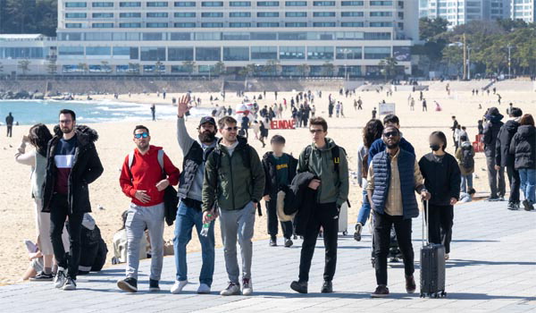 부산 해운대해수욕장에서 외국인 관광객들이 해변을 거닐고 있다. 국제신문DB