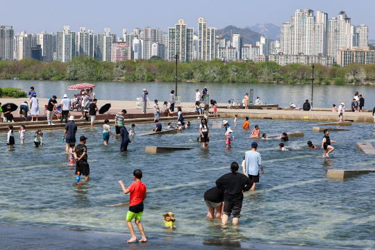 서울 한낮 기온이 29도까지 오르며 초여름 날씨를 보인 지난달 14일 시민들이 서울 영등포구 여의도한강공원 물빛광장에서 물놀이를 즐기고 있다. 연합뉴스