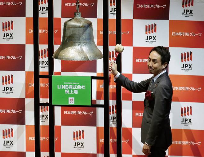 2016년 도쿄증시에 라인야후가 상장된 이후 이데자와 다케시 최고경영자(CEO)가 도쿄 증권거래소에서 주식 거래 시작을 기념하는 종 옆에 서있다. ⓒEPA 연합