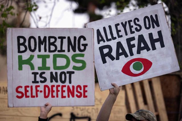 친팔레스타인 시위대가 7일 미국 캘리포니아주 로스앤젤레스 캘리포니아주립대(UCLA)에서 이스라엘의 라파 공습을 반대하는 팻말을 들고 있다. 로스앤젤레스=AFP 연합뉴스