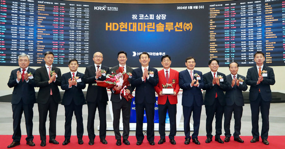 From left to right, starting from fifth, HD Hyundai Vice Chairman Chung Ki-sun, Chairman of Korea Exchange Jeong Eun-bo and CEO of HD Hyundai Marine Solution Lee Ki-dong pose for a photo at HD Hyundai Marine Solution' Kospi listing ceremony. [HD HYUNDAI MARINE SOLUTION]