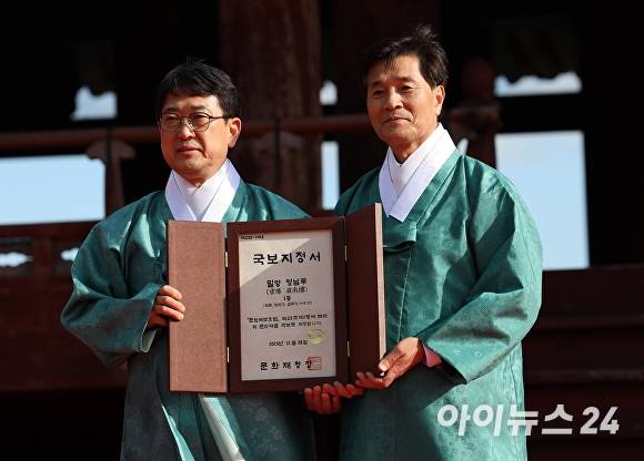 지난 8일 오후 경상남도 밀양시 영남루에서 열린 영남루 국보 승격 기념식 행사에서 최응천 문화재청장(왼쪽)이 안병구 밀양시장(오른쪽)에게 국보지정서 전달을 하고 있다. [사진=임승제 기자]