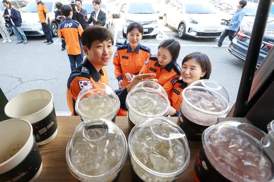 박건기 소방위(사진 왼쪽)가 8일 오전 서울 동작소방서에서 고3 딸 지안 양이 어버이 날을 맞아 보낸 커피차를 선물 받고 동료들에게 커피와 샌드위치를 나눠주고 있다. 뉴스1