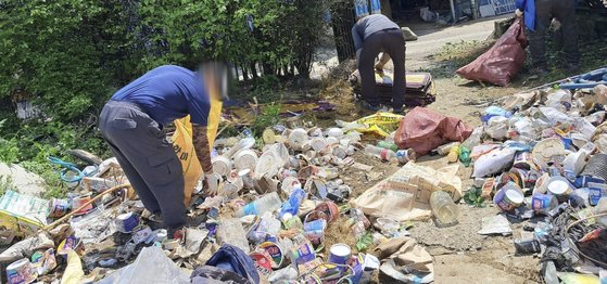 경남 함안군 대산면 한 주택 안팎에 쌓인 쓰레기를 함안지역자활센터 직원들이 치우고 있다. 이 집에서는 사흘간 2.5t 쓰레기가 나왔다. 사진 경남도