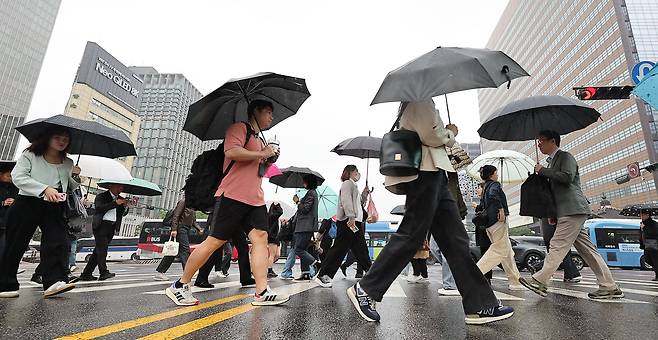 전국 대부분 지역에 비가 예보된 7일 오전 서울 종로구 세종대로사거리에서 우산을 쓴 시민들이 발걸음을 옮기고 있다. 2024.5.7/뉴스1