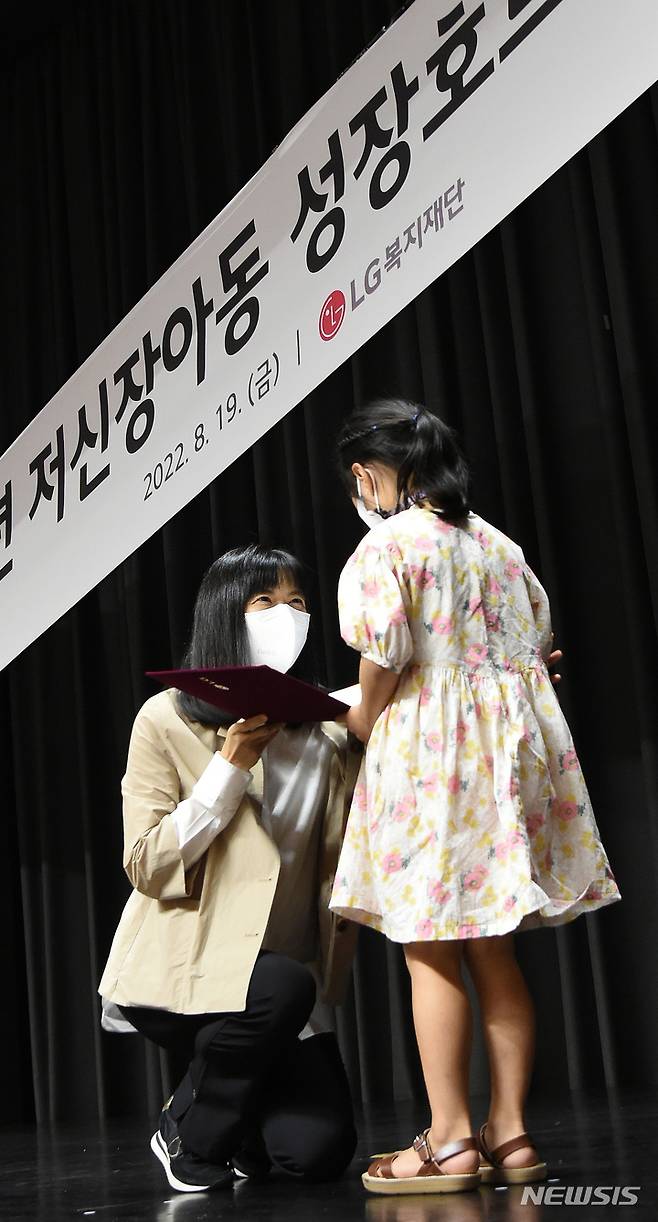 [서울=뉴시스]서울 마곡 LG사이언스파크에서 진행된 '저신장아동 성장호르몬제 기증식'에서 구연경 LG복지재단 대표이사(왼쪽)가 어린이에게 기증서를 전달하고 있다.(사진=LG 제공) 2022.8.21 photo@newsis.com