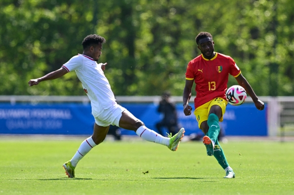 OLY-FBL-U23-CAF-AFC-INA-GUI - Indonesia‘s defender#13 Bagas Kaffa (L) fights for the ball with Guinea’s defender #13 Madiou Keita during the pre-Olympic play-off match between Indonesia and Guinea, for final spot in the men?s Olympic football tournament at Paris 2024, in Clairefontaine-en-Yvelines, south of Paris, on May 9, 2024. (Photo by MIGUEL MEDINA / AFP)