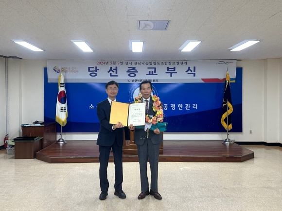 전남낙농업협동조합장 보궐선거에서 당선된 강동준(오른쪽) 후보가 박남천 순천시선거관리위원장으로부터 당선증을 교부받고 있다.