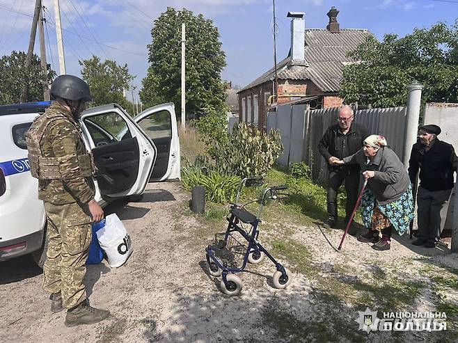 [보우차스크=AP/뉴시스] 우크라이나 경찰이 제공한 사진에 10일(현지시각) 우크라이나 하르키우주 보우차스크 마을에서 경찰관들이 노인들을 러시아의 공격으로부터 대피시키고 있다. 우크라이나군 당국은 국경을 넘어 하르키우주로 진입한 러시아군과 치열한 전투를 벌이고 있다고 전했다. 2024.05.11.