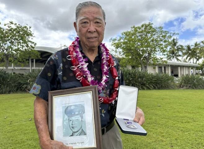 일본계 미국인 윌프레드 이케모토가 10일(현지시간) 제2차 세계대전 도중 전사한 형 하루유키의 사진(왼쪽), 그리고 사후 79년 만에 미군이 수여한 퍼플하트 훈장을 든 채 기념촬영을 하고 있다. AP연합뉴스