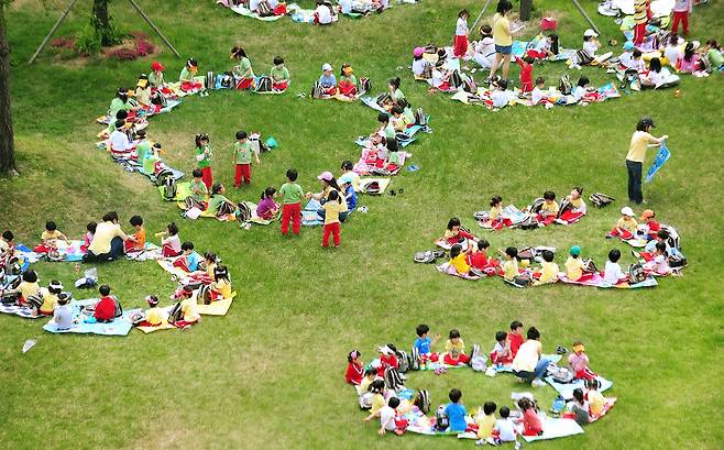 광주에서 소풍 나온 어린이들이 잔디밭에 둥글게 모여 앉아 예쁜 그림을 만들었다. 2011년 [연합뉴스 자료사진]
