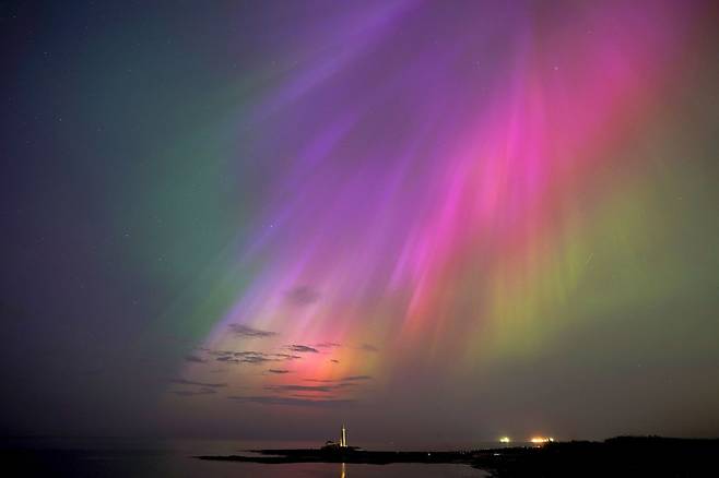 10일(현지 시각) 영국 노스이스트 코스트의 휘틀리 베이에 있는 세인트 메리 등대 상공에 북극광(오로라)이 빛나고 있다. AP 뉴시스