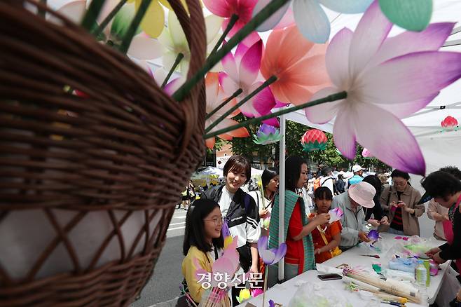 불기 2568년 부처님 오신 날을 사흘 앞둔 12일 서울 종로구 조계사 일대에서 열린 전통문화마당을 찾은 시민들이 지화를 만들고 있다.