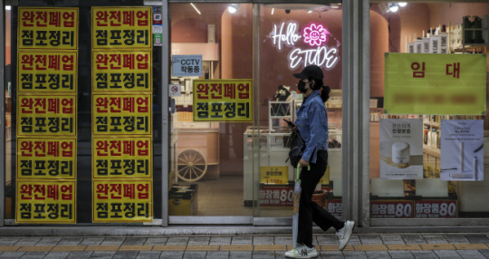 지난 7일 서울 서대문구 연세로의 폐업한 상점 앞을 한 시민이 지나가고 있다. 뉴시스