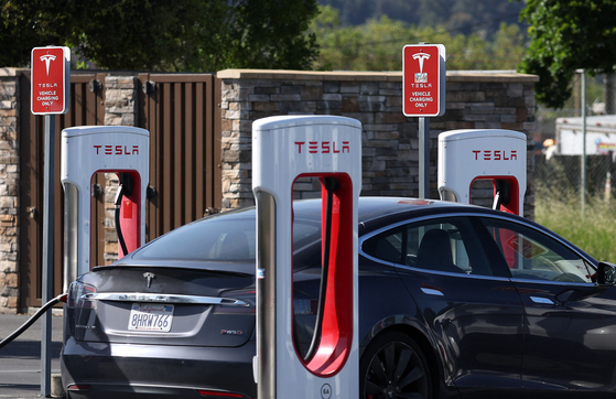 A Tesla car charges at a Tesla Supercharger in Petaluma, California on May 2. LG Energy Solution supplies batteries to Tesla. [AFP/YONHAP]