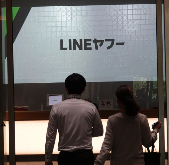 Workers pass by the Line Yahoo's headquarters in Tokyo, Japan, on Thursday. [YONHAP]