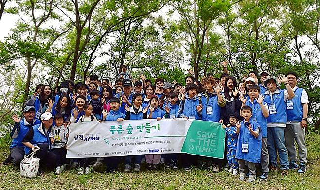지난 11일 서울 상암동 노을공원에서 ‘푸른숲 만들기’ 봉사활동에 참여한 삼정KPMG 임직원과 가족들이 기념촬영을 하고 있다. /사진=삼정KPMG