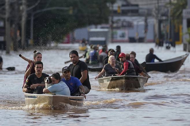 [포르투알레그리=AP/뉴시스] 브라질 남부 히우그랑지두수주에 폭우와 홍수가 발생해 7일(현지시각) 포르투알레그리에서 자원봉사자들이 침수 지역 주민들을 배에 태워 대피시키고 있다. 2024.05.08. /사진=민경찬