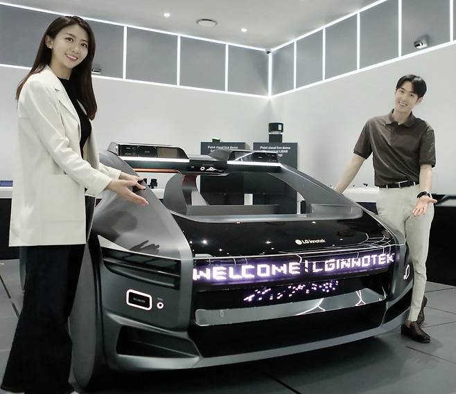 LG이노텍 직원들이 미래차 목업(Mock-up)에 장착된 차량 조명 모듈 ‘넥슬라이드’를 선보이고 있다. [LG이노텍 제공]