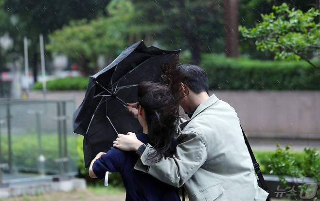 서울 종로구 도심을 지나는 한 시민들이 강한 바람에 위태로운 모양의 우산에 의지한 채 발걸음을 재촉하고 있다. ⓒ News1 박정호 기자