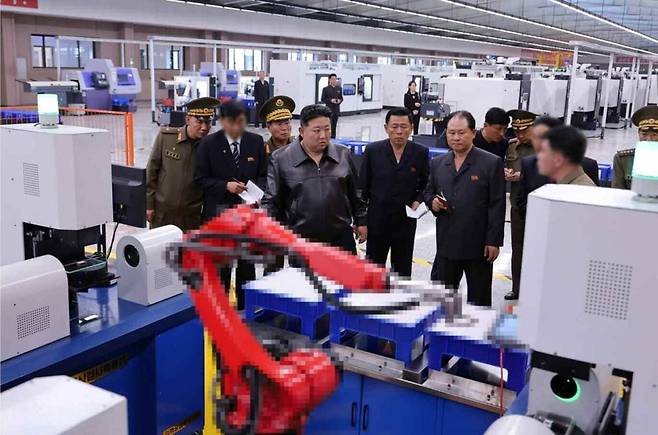 김정은이 11~12일 중요국방공업기업소 현지 점검을 하고 있다. 앞에 놓인 붉은 로봇팔이 모자이크 처리가 돼 있다. /노동신문,뉴스1