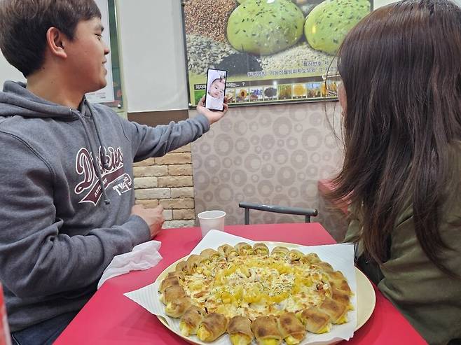 필리핀인 제이비·그레이스가 지난 2일 저녁 충북 음성군 금왕읍의 한 피자집에서 피자를 시켜놓고 필리인에 있는 아들과 영상통화를 하고 있다. 최예린 기자