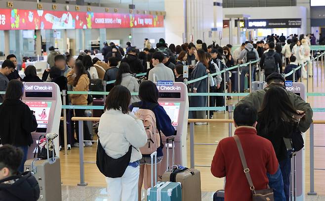 인천국제공항 제1여객터미널에서 일본 등 해외로 향하는 여행객들이 탑승 수속을 위해 줄을 서고 있다. 연합뉴스